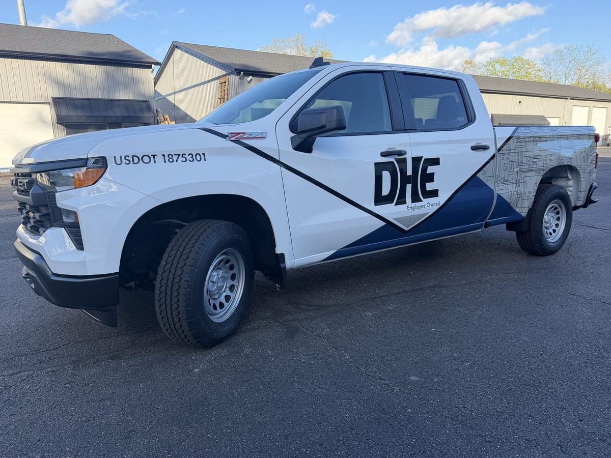 DHE Plumbing fleet trucks with matching graphics installed by Good Graphics Co.